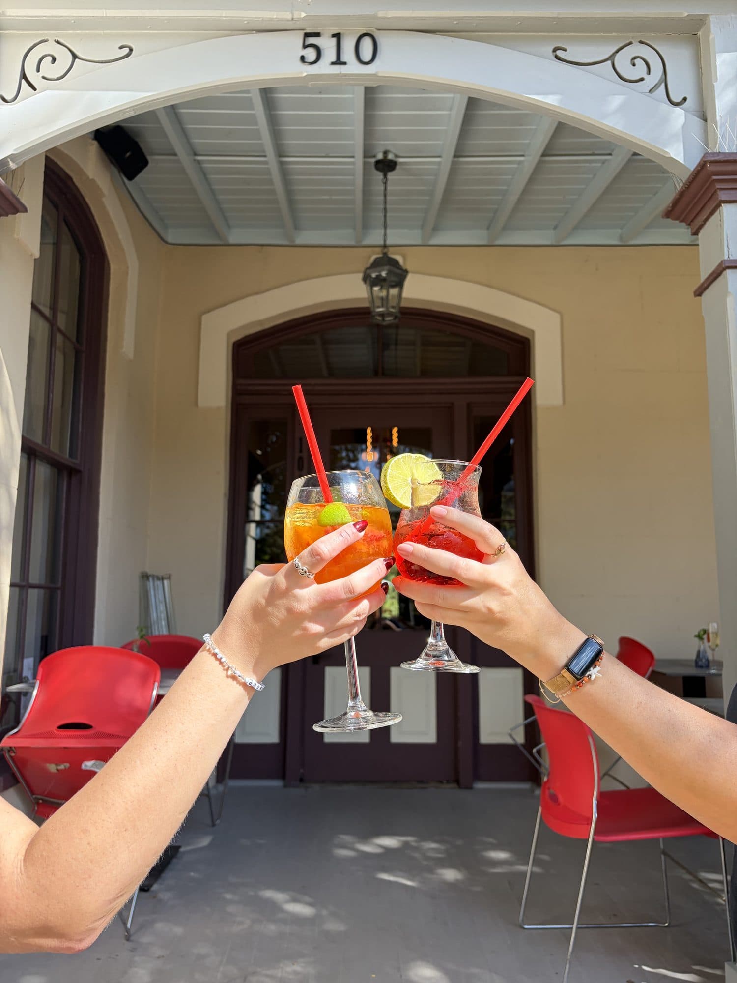 Two guests toasting with spritzes under the 510 archway of the Pereida House